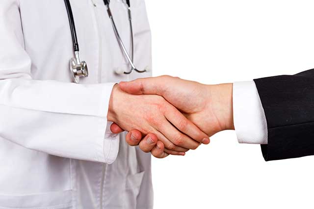 man in black suit shaking a doctor's hand